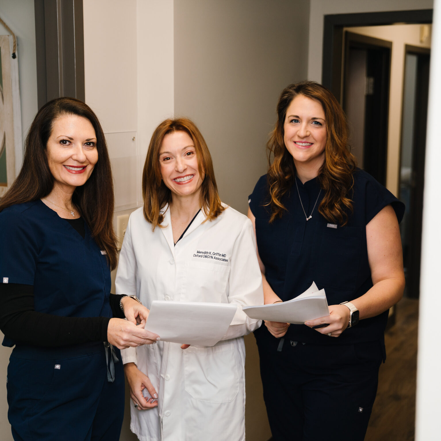 Three Oxford OBGYN staff members reviewing patient paperwork together